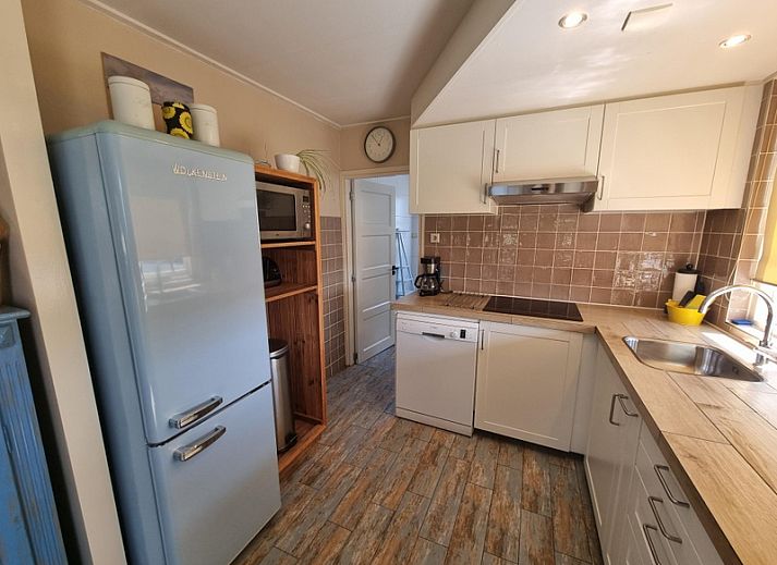 View of Weidezicht in De Dennen, Texel, surrounded by greenery and clear blue sky.