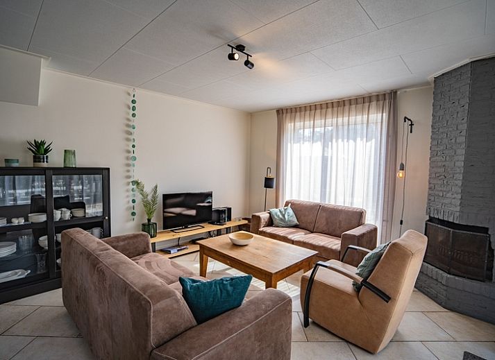 Aussenansicht des Ferienhauses 't Hoogelandt 136 in De Dennen, Texel, mit sonniger Terrasse und gruener Umgebung.