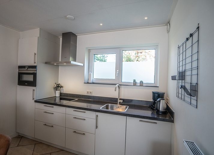 Gemuetliches Wohnzimmer im Ferienhaus 't Hoogelandt 136, De Dennen, Texel, mit moderner Einrichtung und bequemen Sitzgelegenheiten.