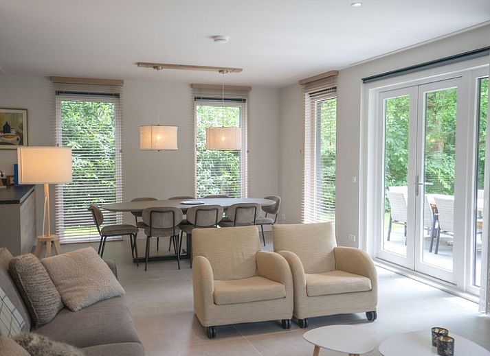 Vacation home de Parel 180 in De Dennen, Texel, surrounded by green nature and a spacious terrace.