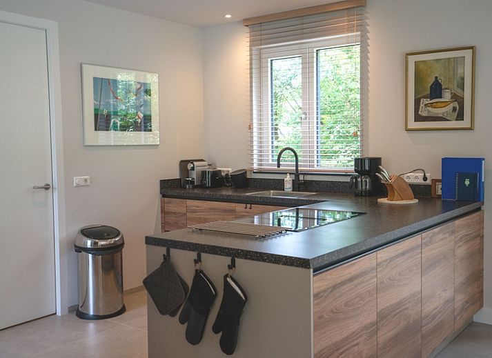 Cozy living room in Holiday home de Parel 180, De Dennen, Texel, overlooking the garden.