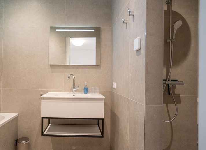 Modern living room in Holiday home de Parel 180, De Dennen, Texel, with comfortable seating area.