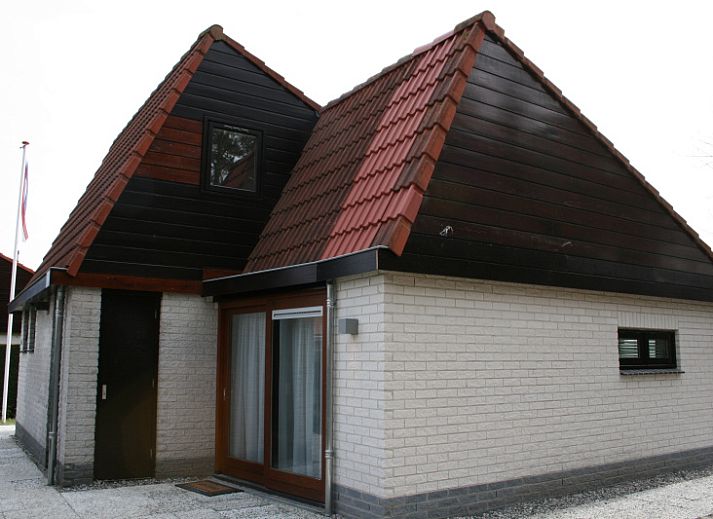 Ferienhaus Gortersmient 354 in De Dennen Texel mit traditioneller Fassade und roten Dachziegeln.