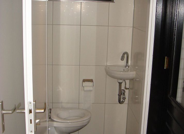 Seitenansicht des von gruenen Hecken umgebenen Ferienhauses Gortersmient 354 in De Dennen Texel.