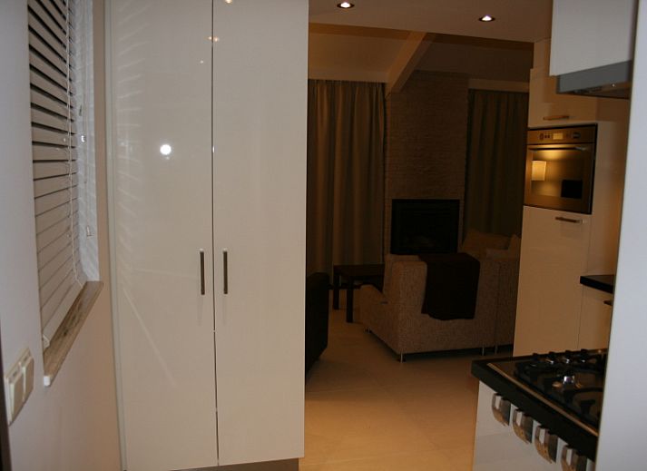 Seitenansicht des von gruenen Hecken umgebenen Ferienhauses Gortersmient 354 in De Dennen Texel.