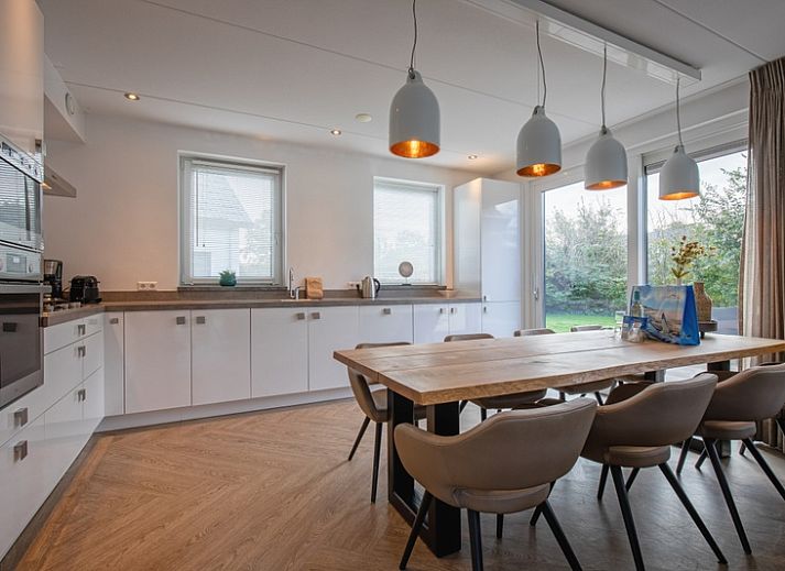 Stilvolles Wohnzimmer der Villa Bloem en Bos in De Dennen, Texel, mit bequemen Sofas und viel Tageslicht.