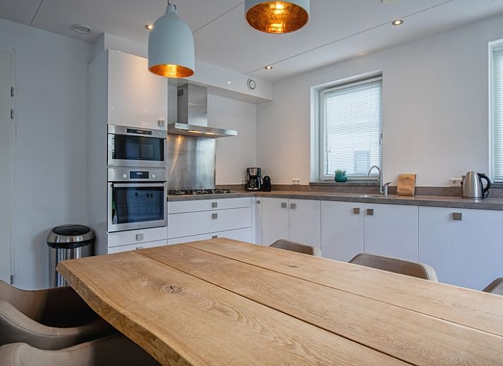 Stilvolles Wohnzimmer der Villa Bloem en Bos in De Dennen, Texel, mit bequemen Sofas und viel Tageslicht.