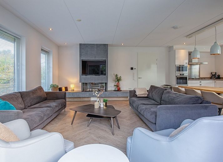 Stilvolles Wohnzimmer der Villa Bloem en Bos in De Dennen, Texel, mit bequemen Sofas und viel Tageslicht.