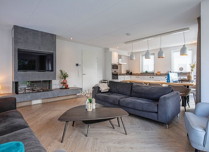 Stilvolles Wohnzimmer der Villa Bloem en Bos in De Dennen, Texel, mit bequemen Sofas und viel Tageslicht.
