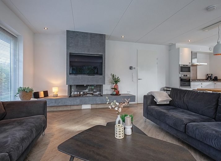 Moderne Essecke im Bungalowpark 't Hoogelandt - Villa Bloem en Bos, Texel mit gemuetlicher Beleuchtung und Holztisch.