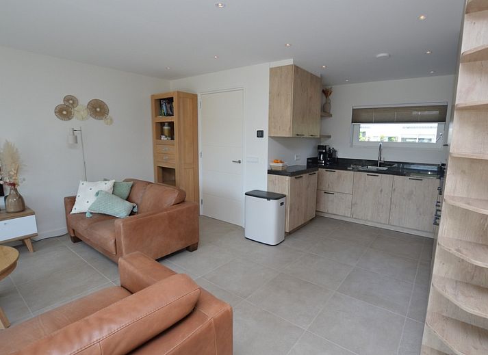 Moderne woonkamer in Tempelierweg - Kogermient 18, De Dennen Texel, met leren banken en open keuken.