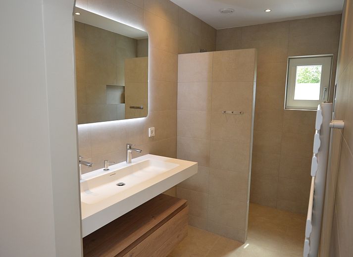 Moderne woonkamer in Tempelierweg - Kogermient 18, De Dennen Texel, met leren banken en open keuken.