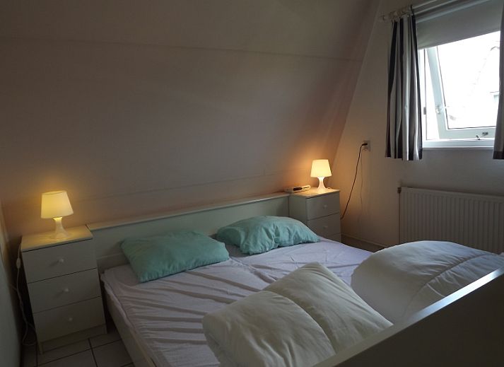 Aussenbereich des Ferienhauses Gortersmient 358 in De Dennen, Texel mit Esstisch und Liegestuehlen.