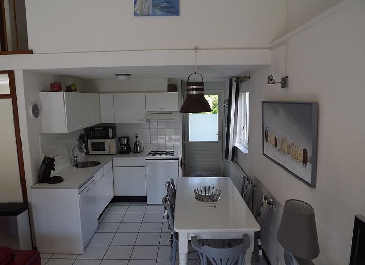 Aussenbereich des Ferienhauses Gortersmient 358 in De Dennen, Texel mit Esstisch und Liegestuehlen.