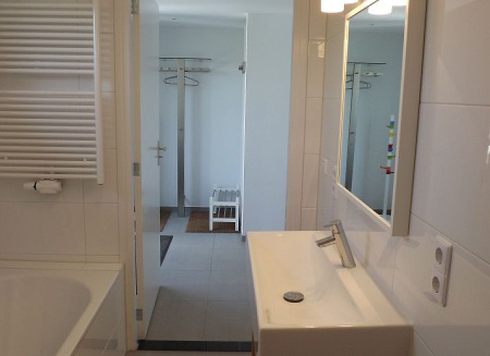 Buitenzijde van Vakantiehuis Gortersmient 320, De Dennen, Texel met comfortabele zithoek en eettafel op het terras, perfect voor buitenleven.