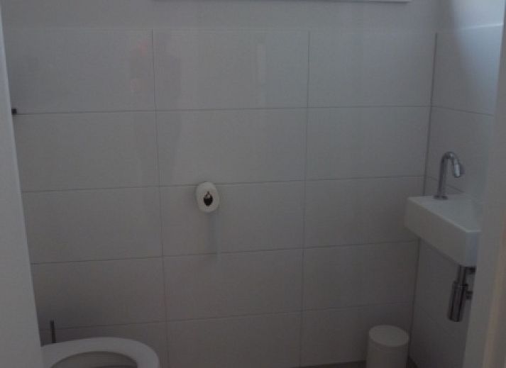 Buitenzijde van Vakantiehuis Gortersmient 320, De Dennen, Texel met comfortabele zithoek en eettafel op het terras, perfect voor buitenleven.