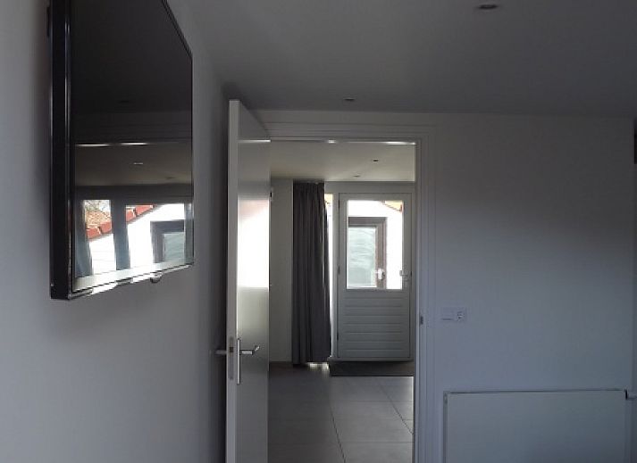 Buitenzijde van Vakantiehuis Gortersmient 320, De Dennen, Texel met comfortabele zithoek en eettafel op het terras, perfect voor buitenleven.