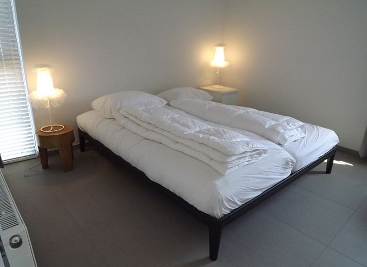 Buitenzijde van Vakantiehuis Gortersmient 320, De Dennen, Texel met comfortabele zithoek en eettafel op het terras, perfect voor buitenleven.