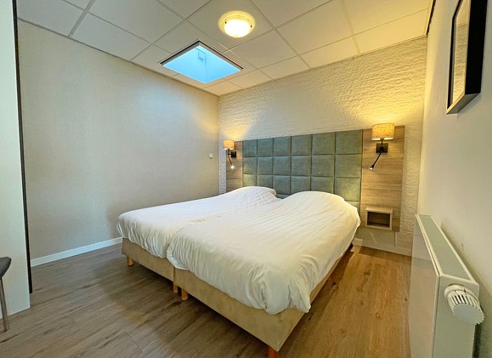 Lichtovergoten woonkamer van Appartement Bos en Duin 19 in De Dennen, Texel met moderne inrichting en uitzicht op natuur.