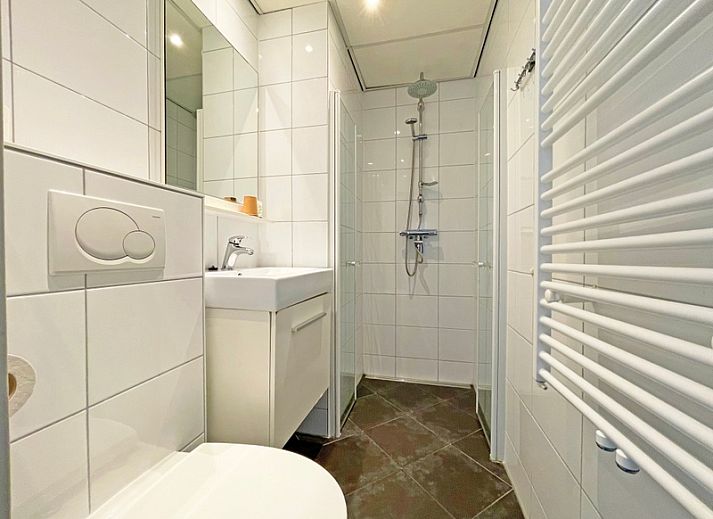 Lichtovergoten woonkamer van Appartement Bos en Duin 19 in De Dennen, Texel met moderne inrichting en uitzicht op natuur.