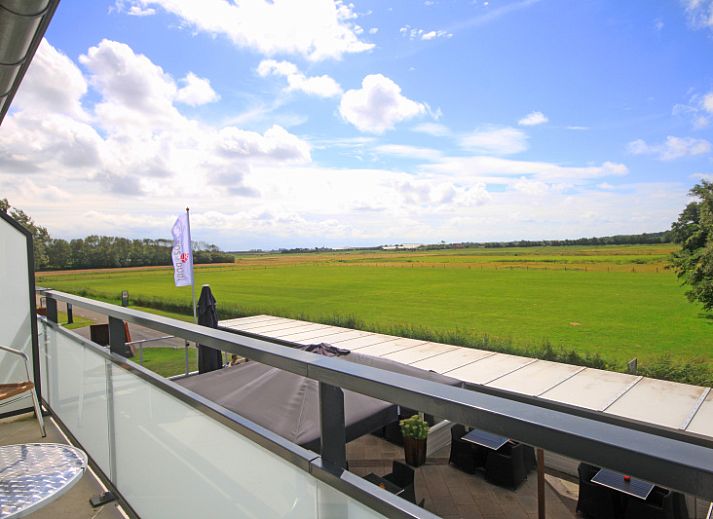 Lichtovergoten woonkamer van Appartement Bos en Duin 19 in De Dennen, Texel met moderne inrichting en uitzicht op natuur.