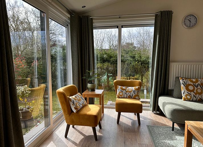 Gezellige woonkamer van Vakantiepark de Bremakker - Weideveld 57, vakantiehuis in De Dennen, Texel met houten meubels en warme sfeer.