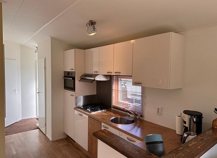 Gezellige woonkamer van Vakantiepark de Bremakker - Weideveld 57, vakantiehuis in De Dennen, Texel met houten meubels en warme sfeer.