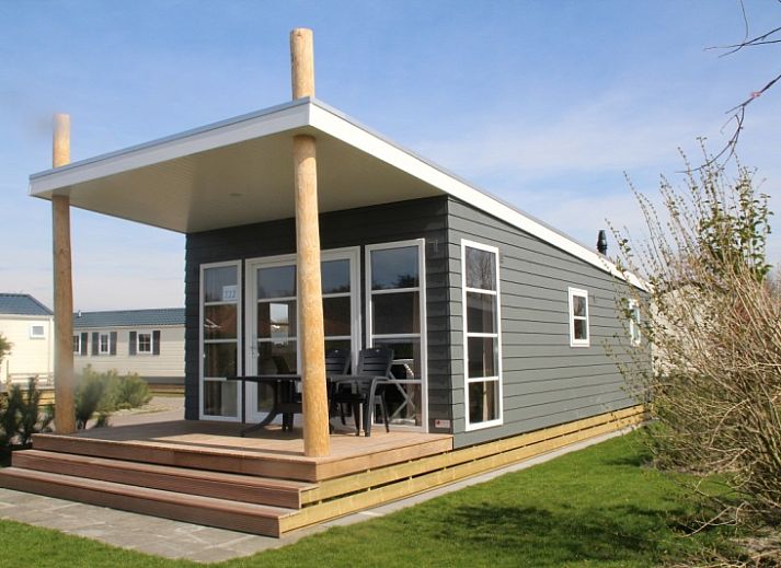 Lodge - 4 persoons in De Dennen, Texel met moderne buitenkant en houten veranda.