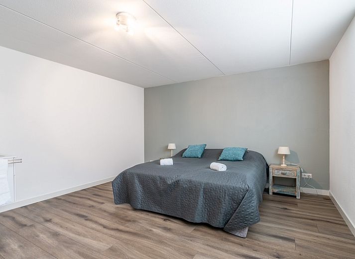 Gemuetliches Wohnzimmer der Villa 106F im Bungalowpark 't Hoogelandt, Texel, mit modernem Kamin und bequemen Sofas.