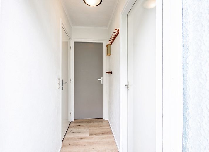 Gezellige woonkamer met open haard in Vakantiehuis de Parel 166, Bungalowpark De Parel, Texel, perfect voor knusse avonden.