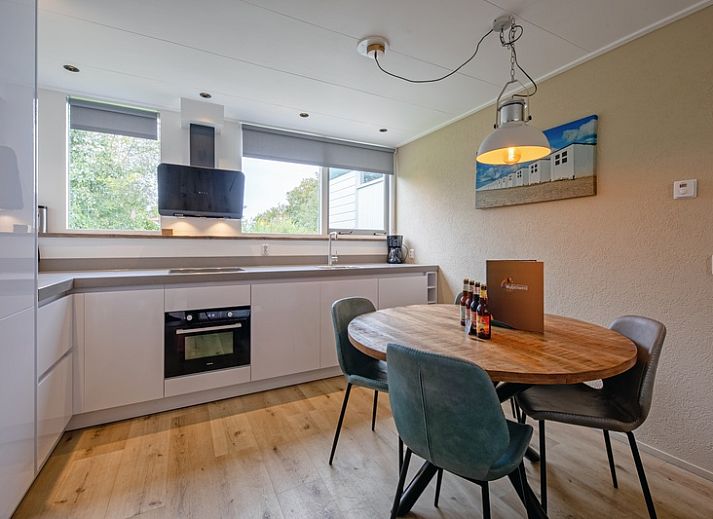 Gezellige woonkamer met open haard in Vakantiehuis de Parel 166, Bungalowpark De Parel, Texel, perfect voor knusse avonden.