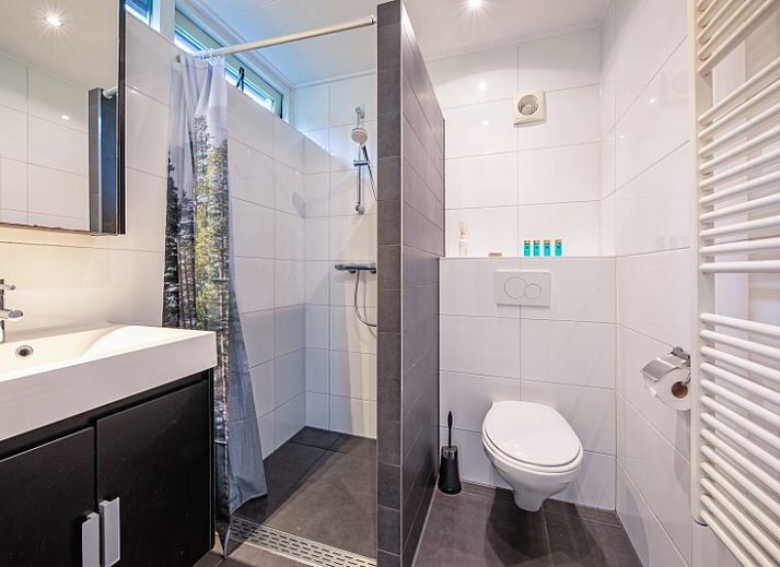 Gezellige woonkamer met open haard in Vakantiehuis de Parel 166, Bungalowpark De Parel, Texel, perfect voor knusse avonden.