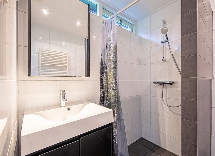 Gezellige woonkamer met open haard in Vakantiehuis de Parel 166, Bungalowpark De Parel, Texel, perfect voor knusse avonden.