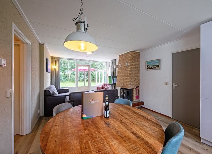 Lichte woonkamer met uitzicht op de tuin in Vakantiehuis de Parel 166, De Dennen, Texel, ideaal voor rustgevende momenten.