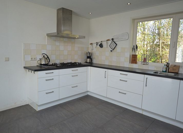 Bright living room in Holiday home de Parel 190, De Dennen, Texel with comfortable seating area and garden view.