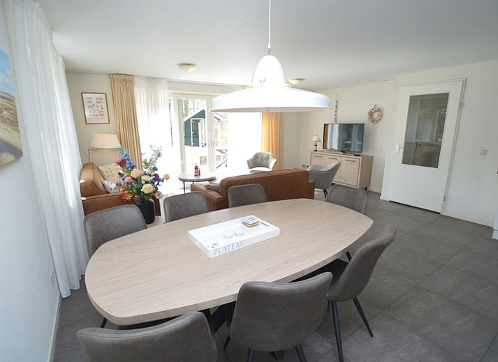 Bright living room in Holiday home de Parel 190, De Dennen, Texel with comfortable seating area and garden view.