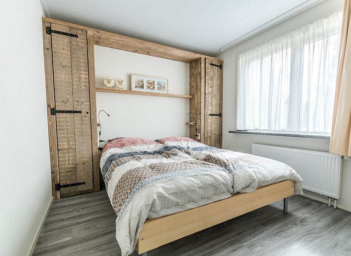 Bright living room in Holiday home de Parel 190, De Dennen, Texel with comfortable seating area and garden view.