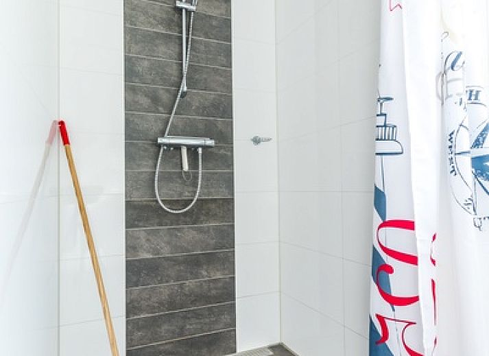 Open kitchen and living room in Holiday home de Parel 190, Texel, with modern furnishings and lots of natural light.