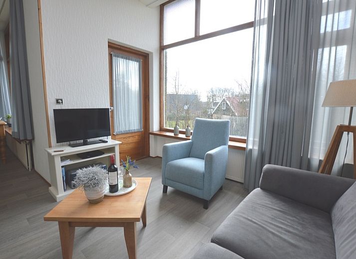 Gemuetliches Wohnzimmer im Ferienhaus Lelie, De Dennen, Texel mit bequemer Sitzecke und grossen Fenstern.