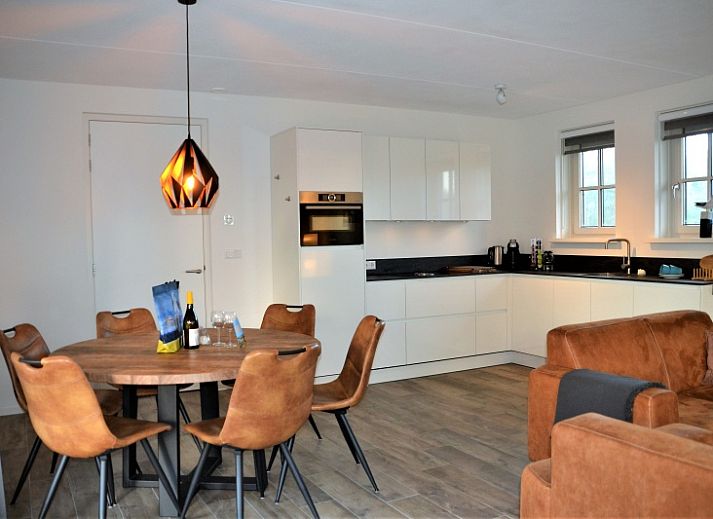 Golden Raand vakantiehuis in De Dennen, Texel, omgeven door groene natuur en blauwe hemel.