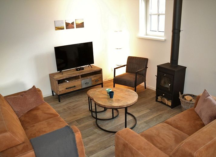 Golden Raand vakantiehuis in De Dennen, Texel, omgeven door groene natuur en blauwe hemel.