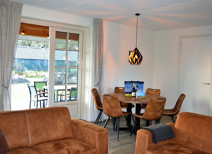 Golden Raand vakantiehuis in De Dennen, Texel, omgeven door groene natuur en blauwe hemel.