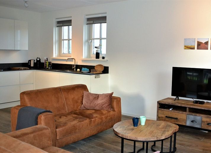 Golden Raand vakantiehuis in De Dennen, Texel, omgeven door groene natuur en blauwe hemel.