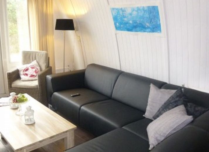 Vooraanzicht van vakantiehuis Sonnevanck op Vlieland, Waddeneilanden, met groene gevel en terras.