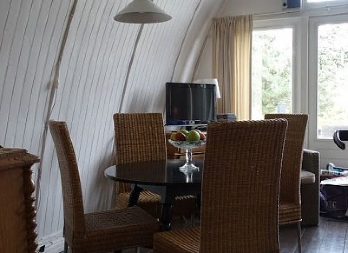 Vooraanzicht van vakantiehuis Sonnevanck op Vlieland, Waddeneilanden, met groene gevel en terras.