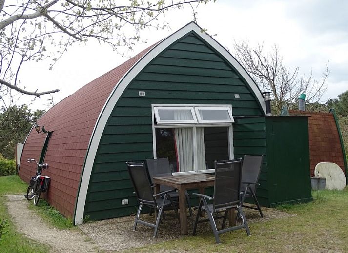 Gezellige woonkamer in Sonnevanck vakantiehuis op Vlieland, Waddeneilanden, met comfortabele zwarte bank.