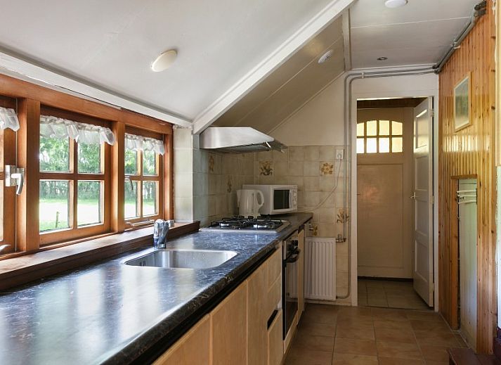 Charmante voorgevel van Meiblok vakantiehuis in Formerum, Terschelling omringd door groene natuur.