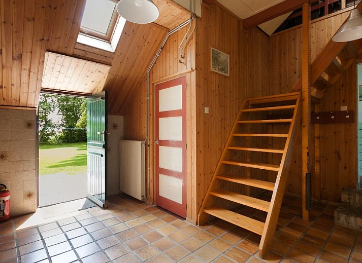 Charmante voorgevel van Meiblok vakantiehuis in Formerum, Terschelling omringd door groene natuur.