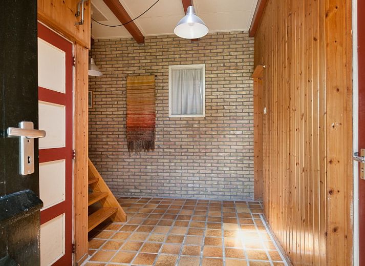 Charmante voorgevel van Meiblok vakantiehuis in Formerum, Terschelling omringd door groene natuur.