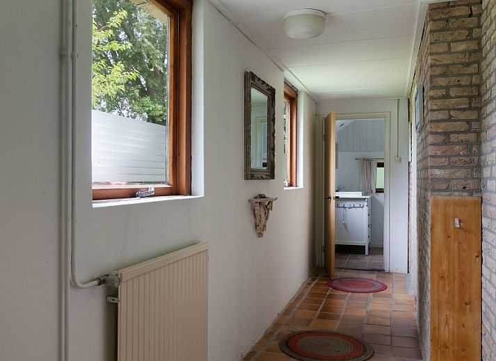 Charmante voorgevel van Meiblok vakantiehuis in Formerum, Terschelling omringd door groene natuur.